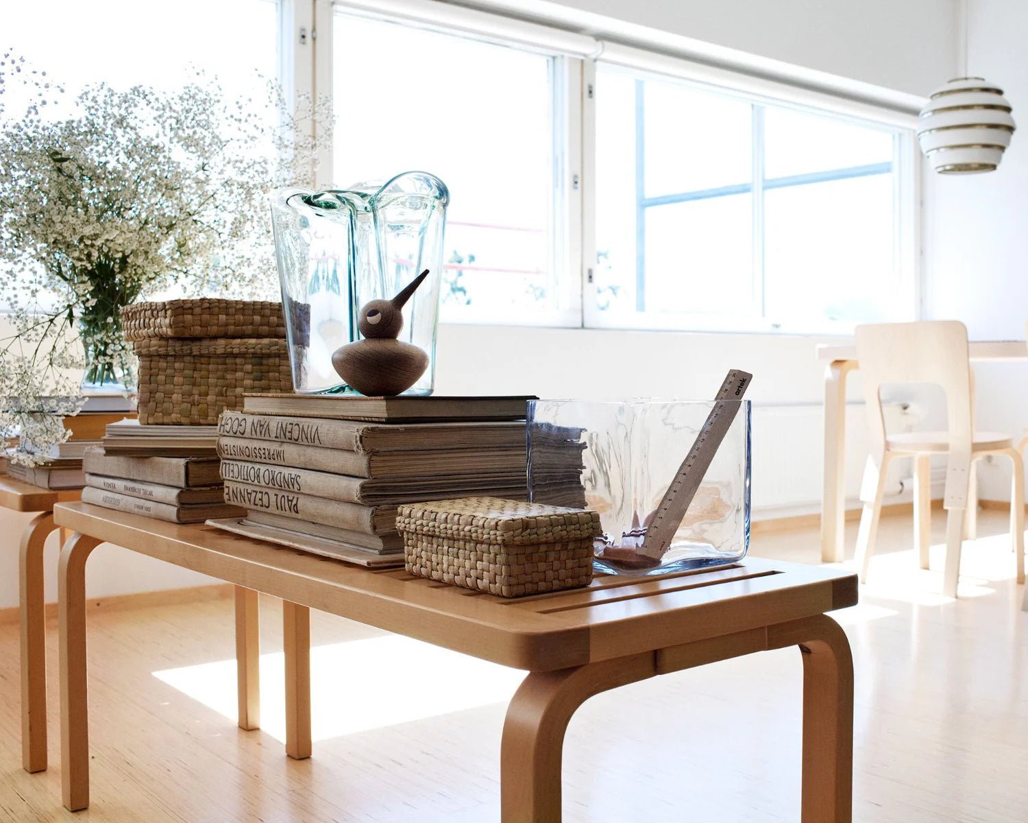 Natural wood bench with slatted top and curved legs, similar to a modular seating piece.