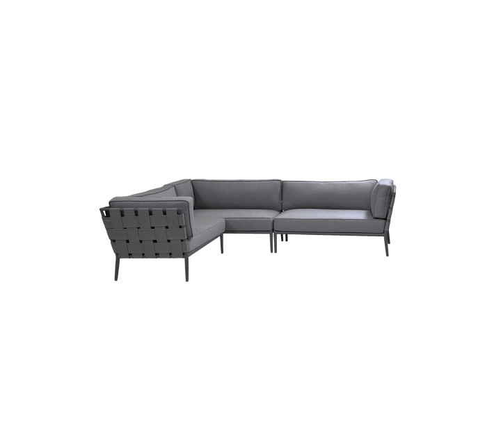 Stylish grey sectional sofa with a modern design and clean lines, featuring a comfortable seating area and a distinctive woven back.