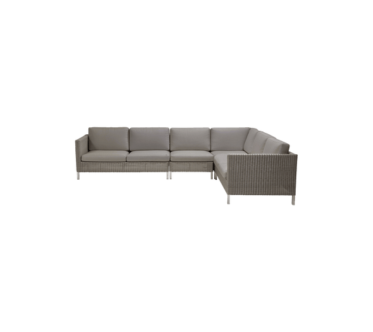 Modern sectional sofa with plush cushions in soft gray upholstery and a woven base, perfect for stylish seating arrangements.