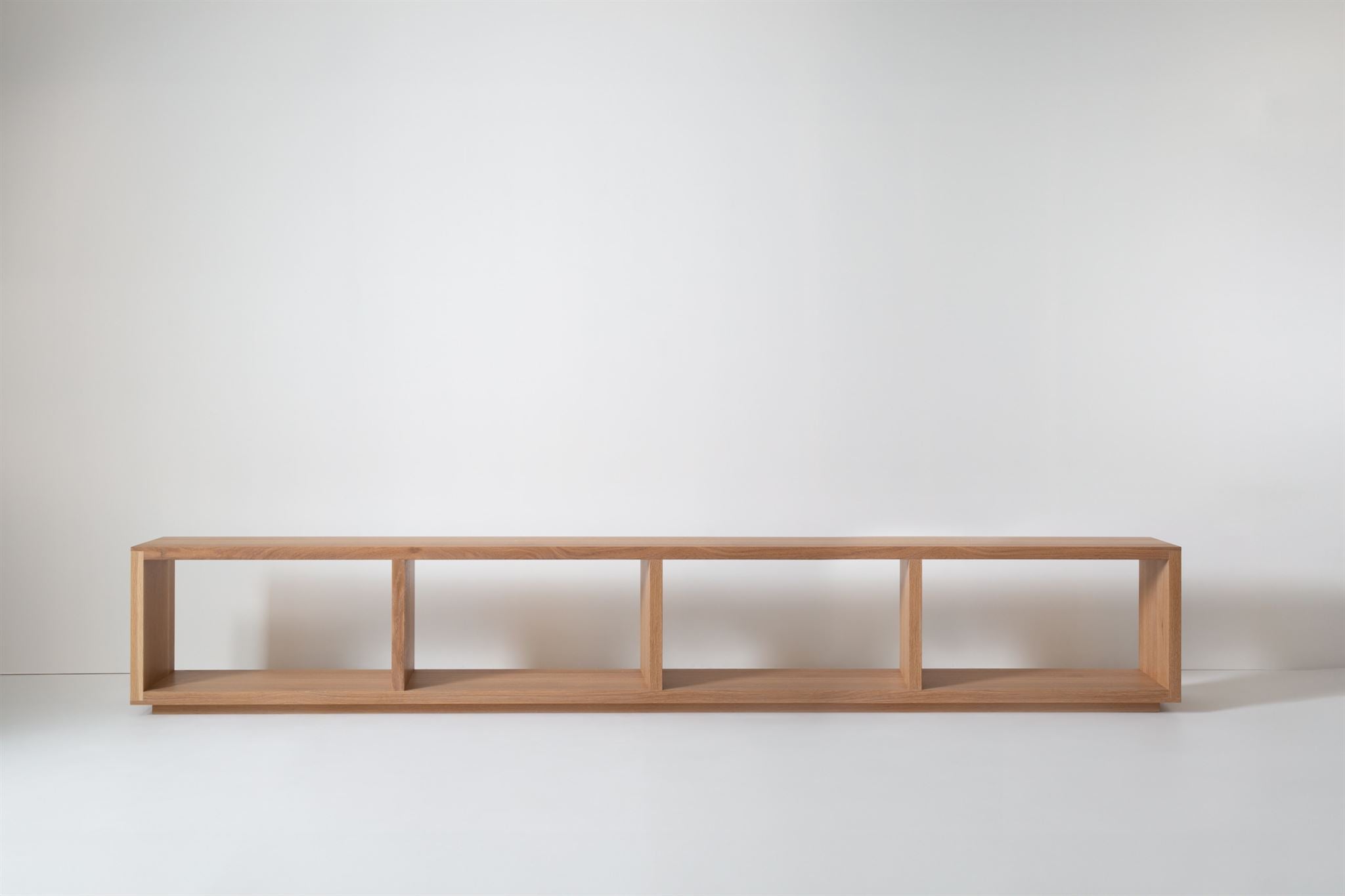 Close-up of cushioned top on bench, showing brown upholstery and wood grain of frame.