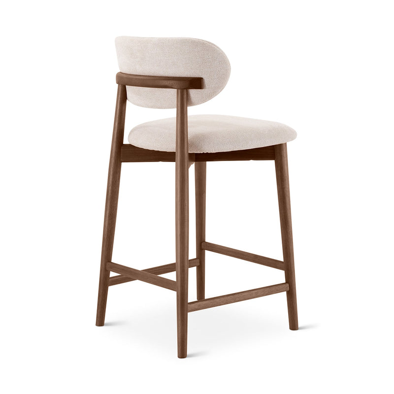 Side view of the same upholstered bar stool displaying wooden frame and footrest.