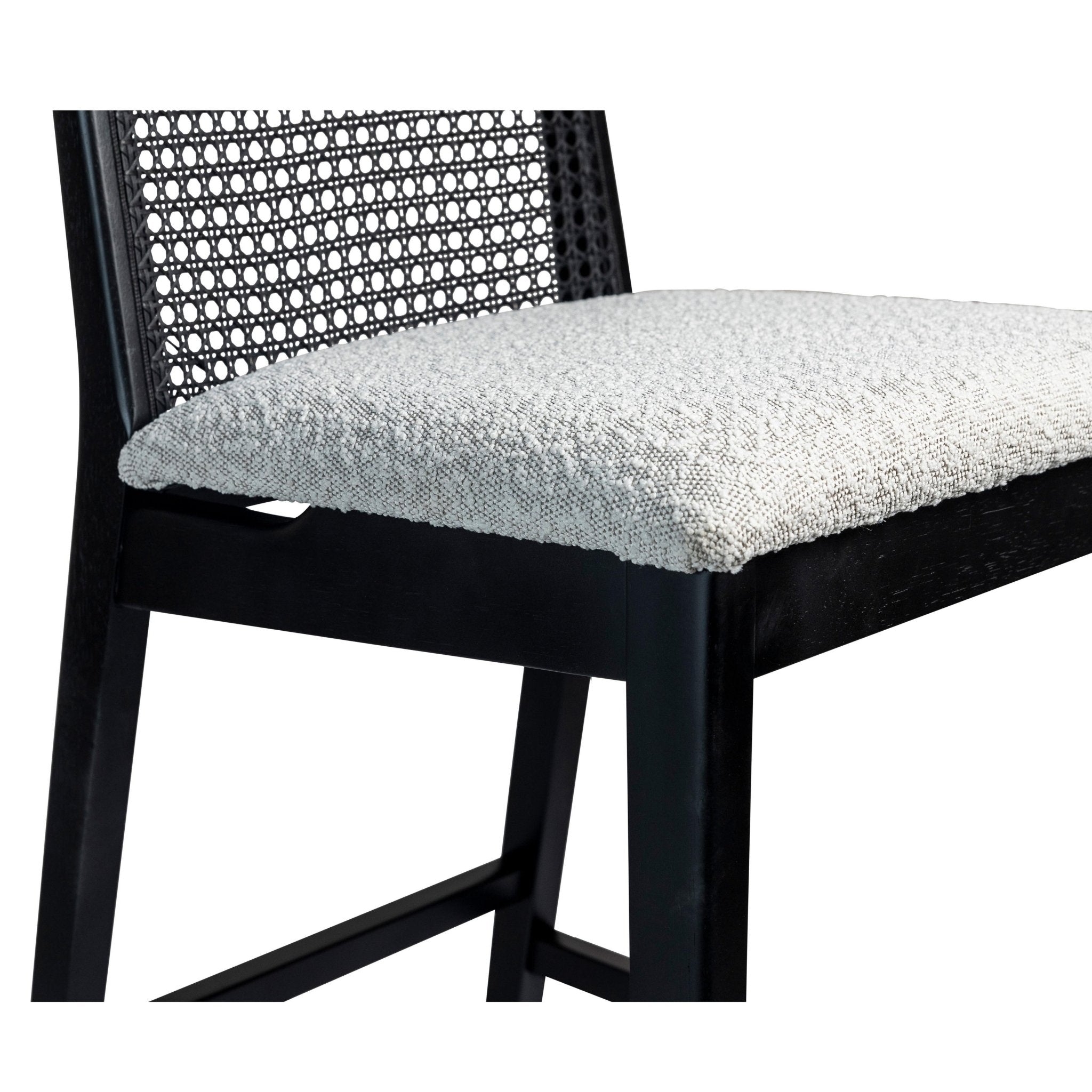 Front view of a black wooden bar stool with caned back and upholstered seat.