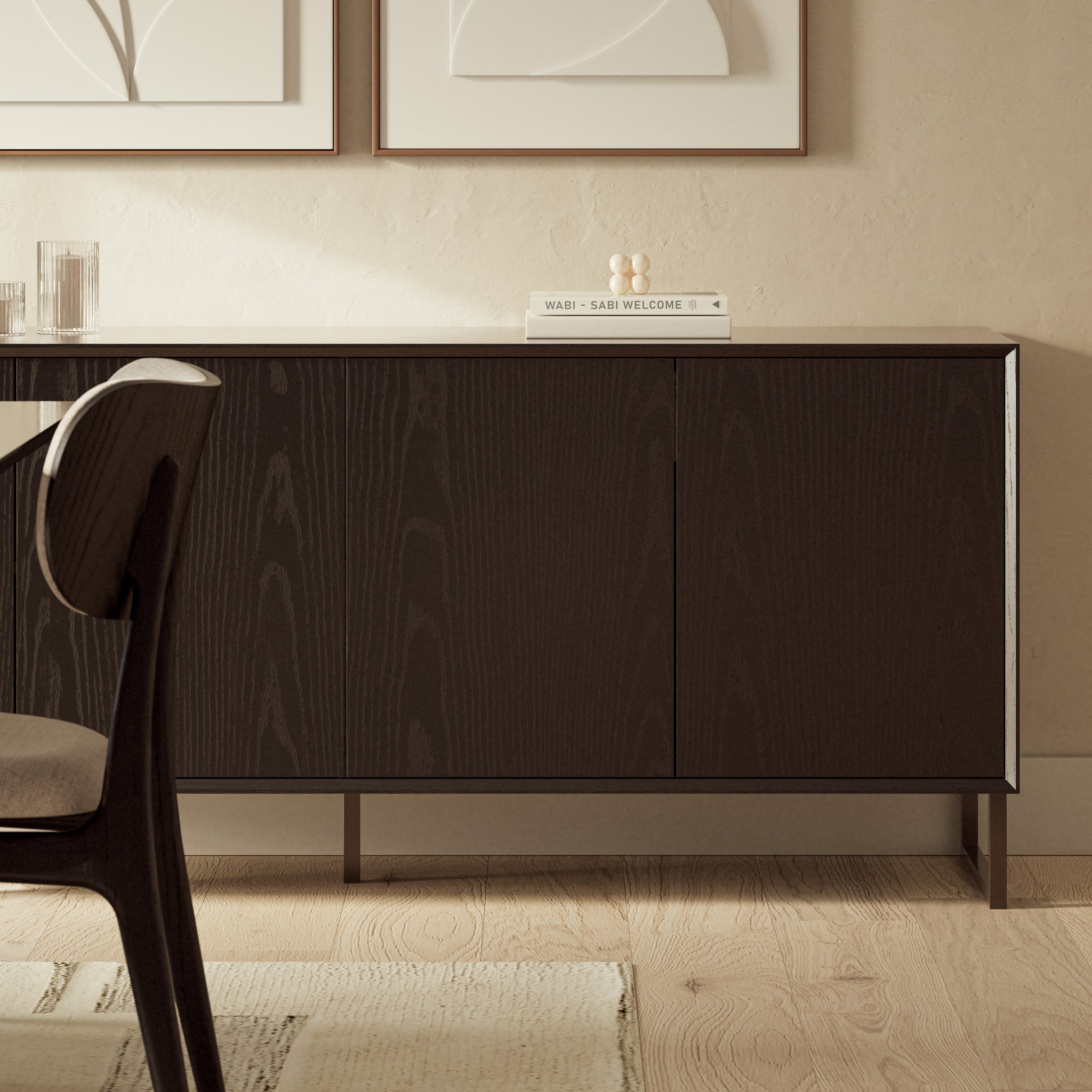 Close-up view of the lower section of a dark wood cabinet showing a slim metal leg and base