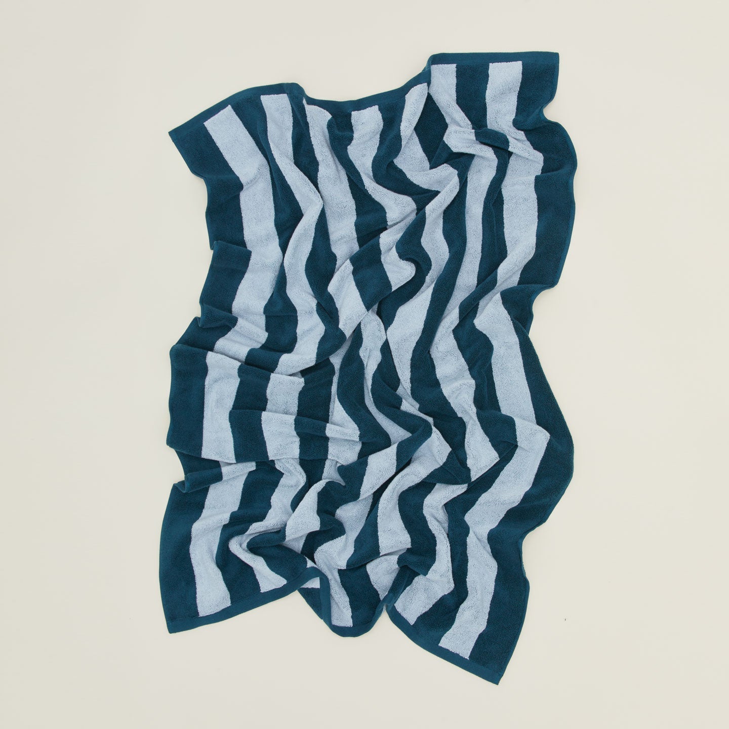 An overhead of a striped light grey and dark grey terry bath towel.
