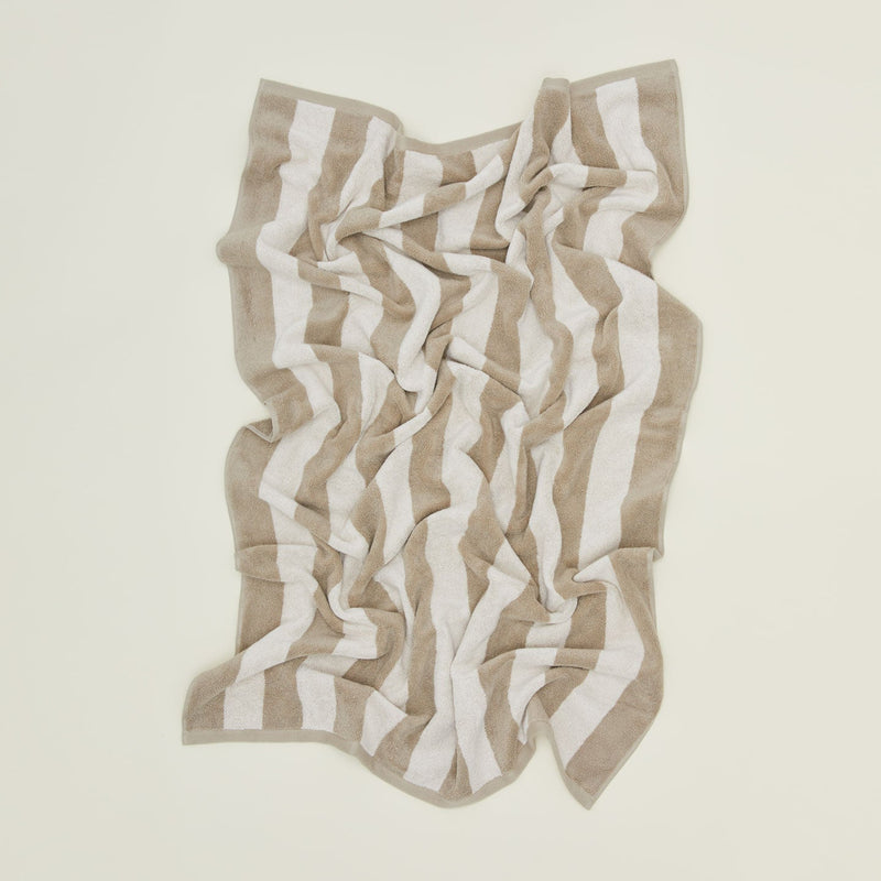 An overhead of a striped sky and peacock terry bath towel.
