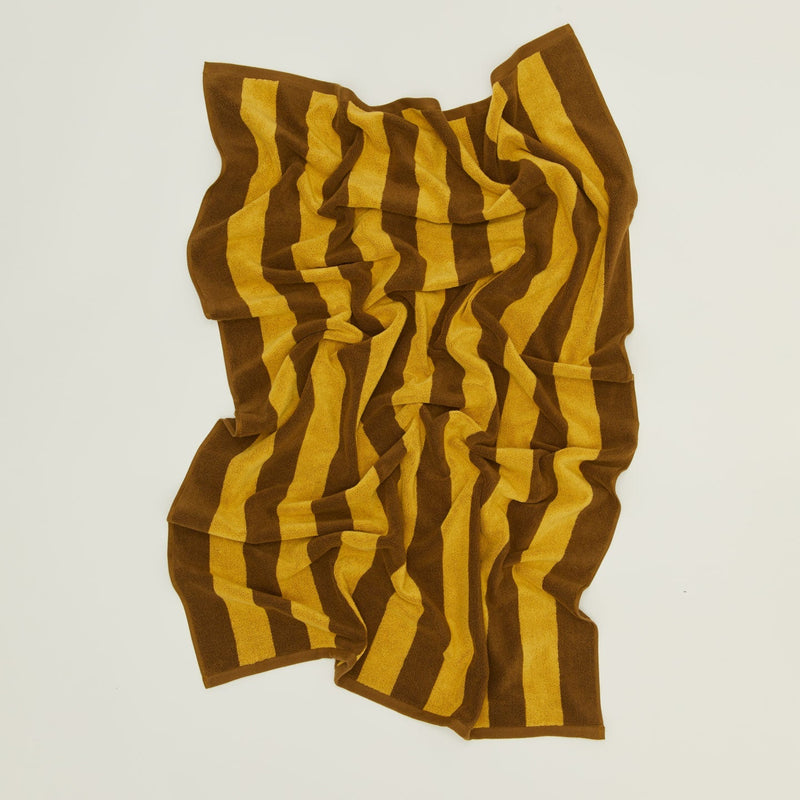 An overhead of a striped sky and peacock terry bath towel.