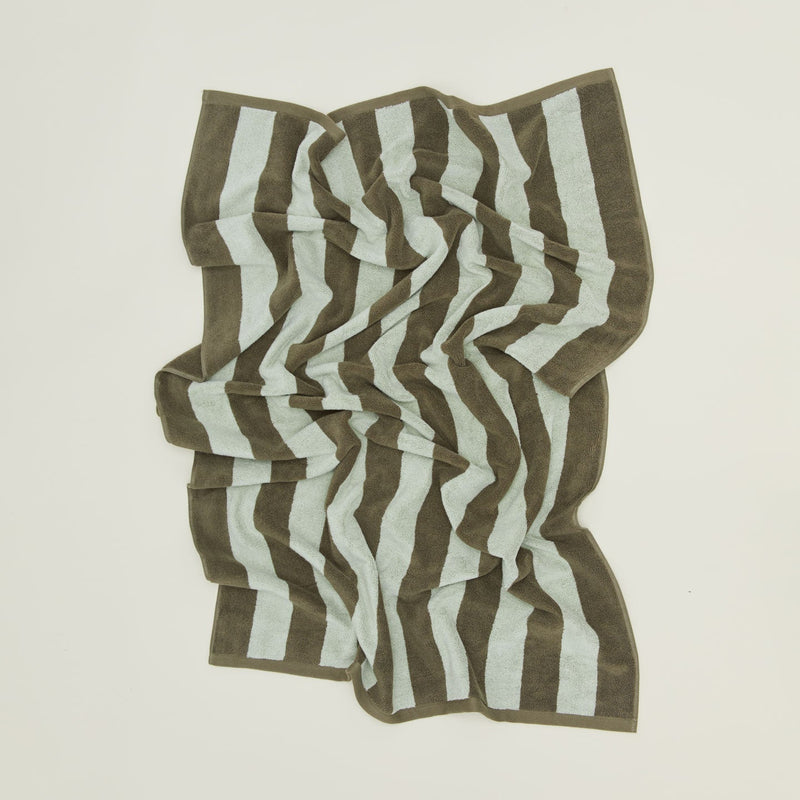 An overhead of a striped sky and peacock terry bath towel.