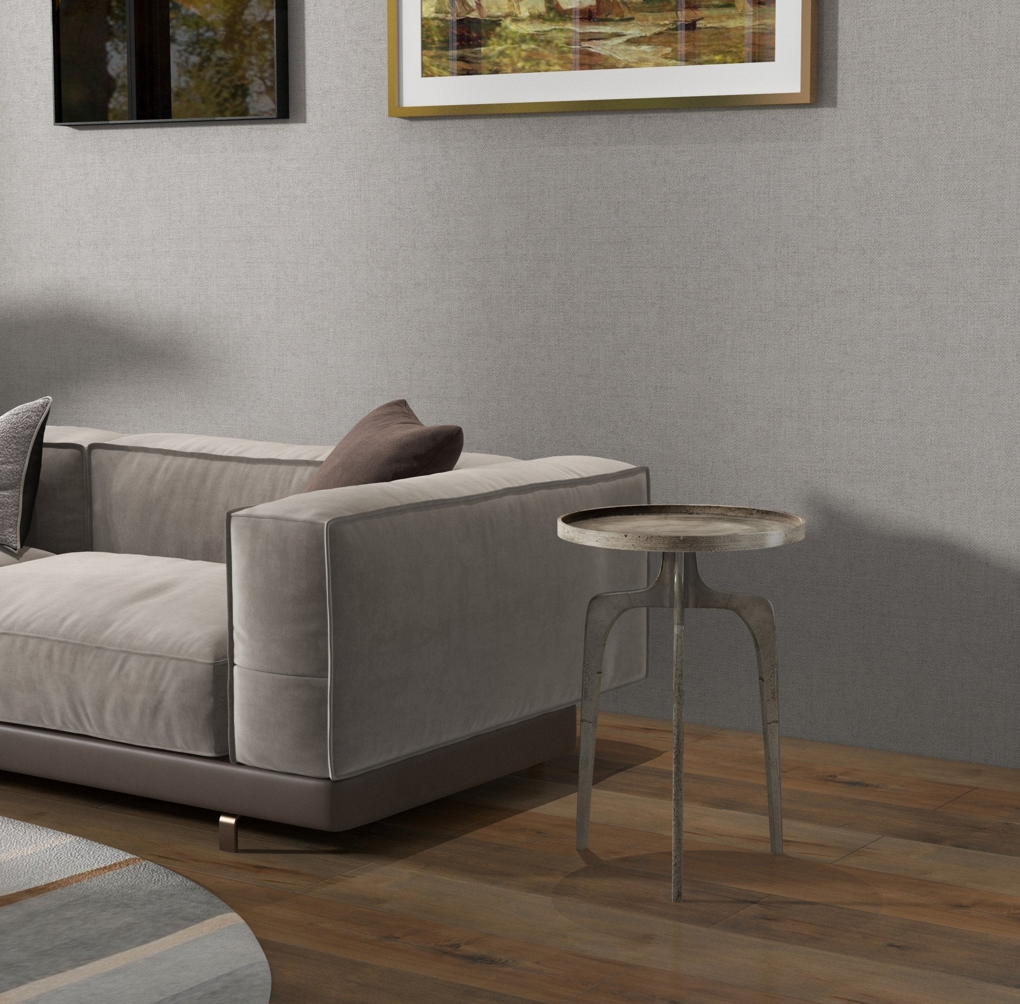 Circular metal top of side table with three legs, showing dark finish.