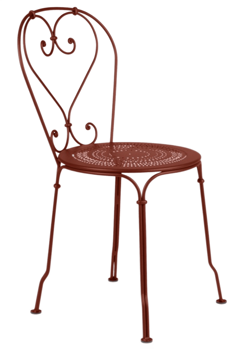 Metal chair in yellow/gold color with perforated seat and decorative back