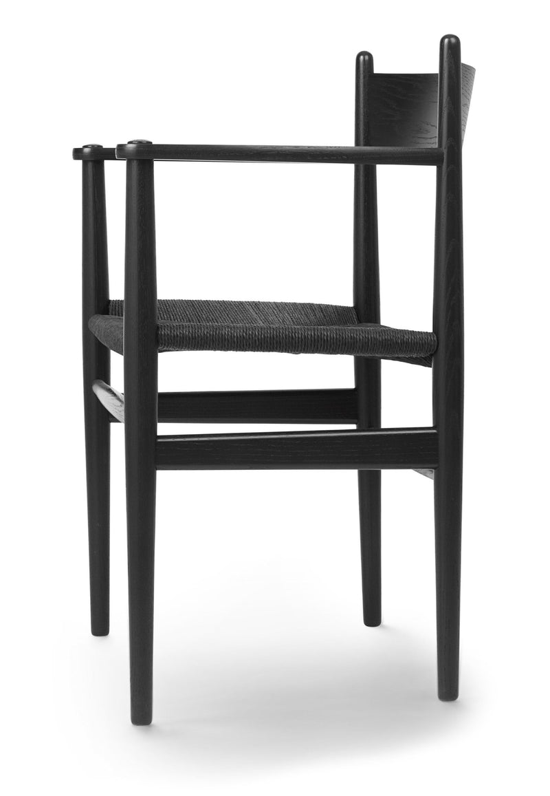 Black wooden armchair with woven seat and slim arms, close-up view