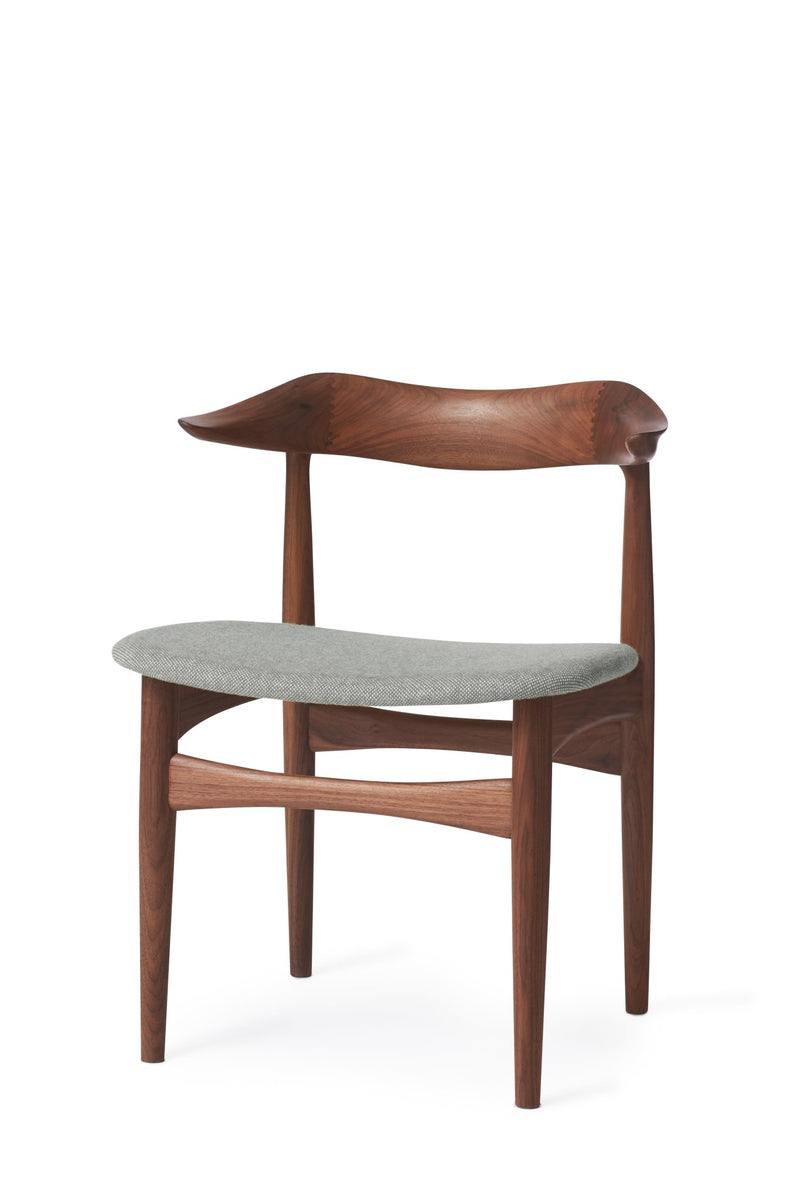 Another view of the same wooden dining chair with light beige seat, showing the curved backrest and leg details.
