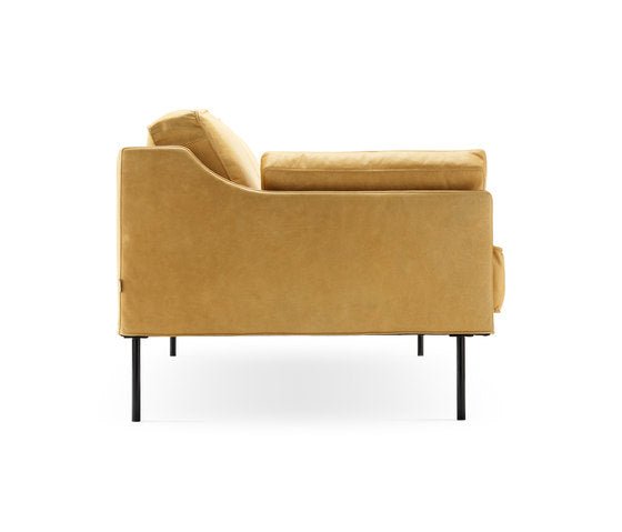 Pair of mustard-yellow leather sofas with metal legs in a studio shot.