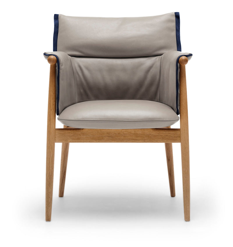 Brownish-gray fabric chair with light wood legs, side angle showing armrest and cushion.