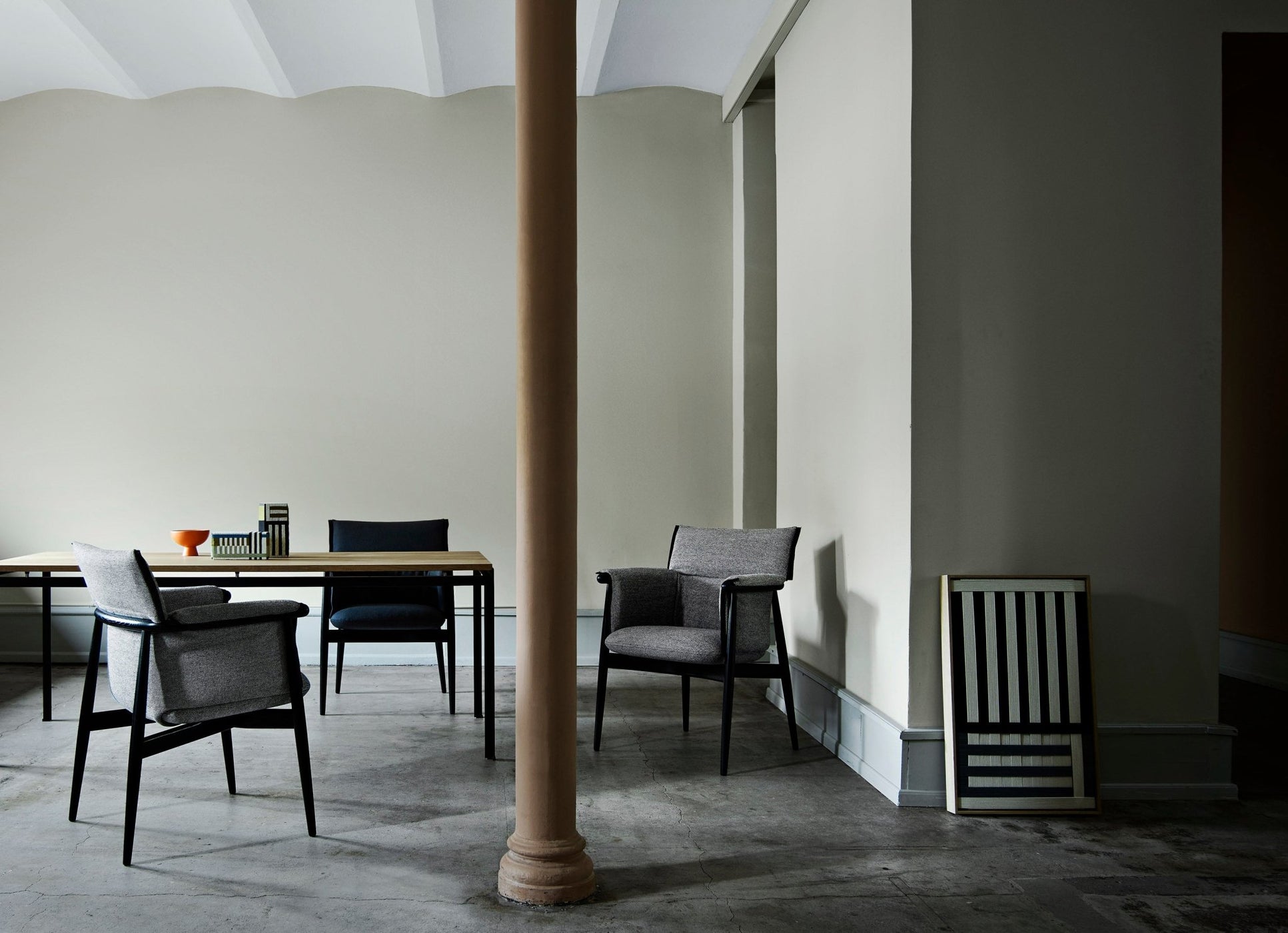 Beige/gray fabric armchair with wooden legs; taupe back cushion, high armrests, front view.