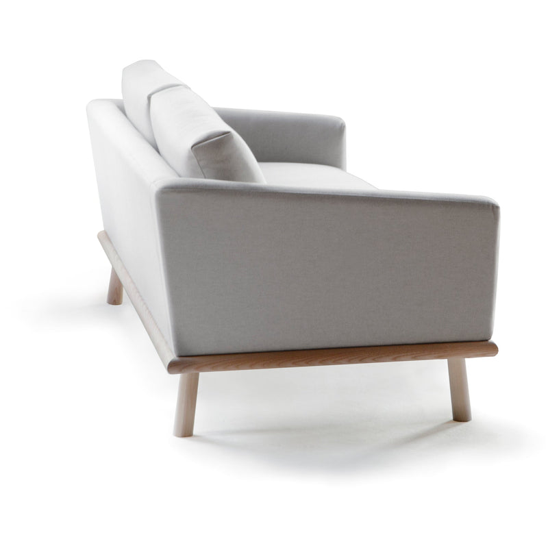 Linea Sofa by Nikari. A modern grey living room couch with a wood frame.