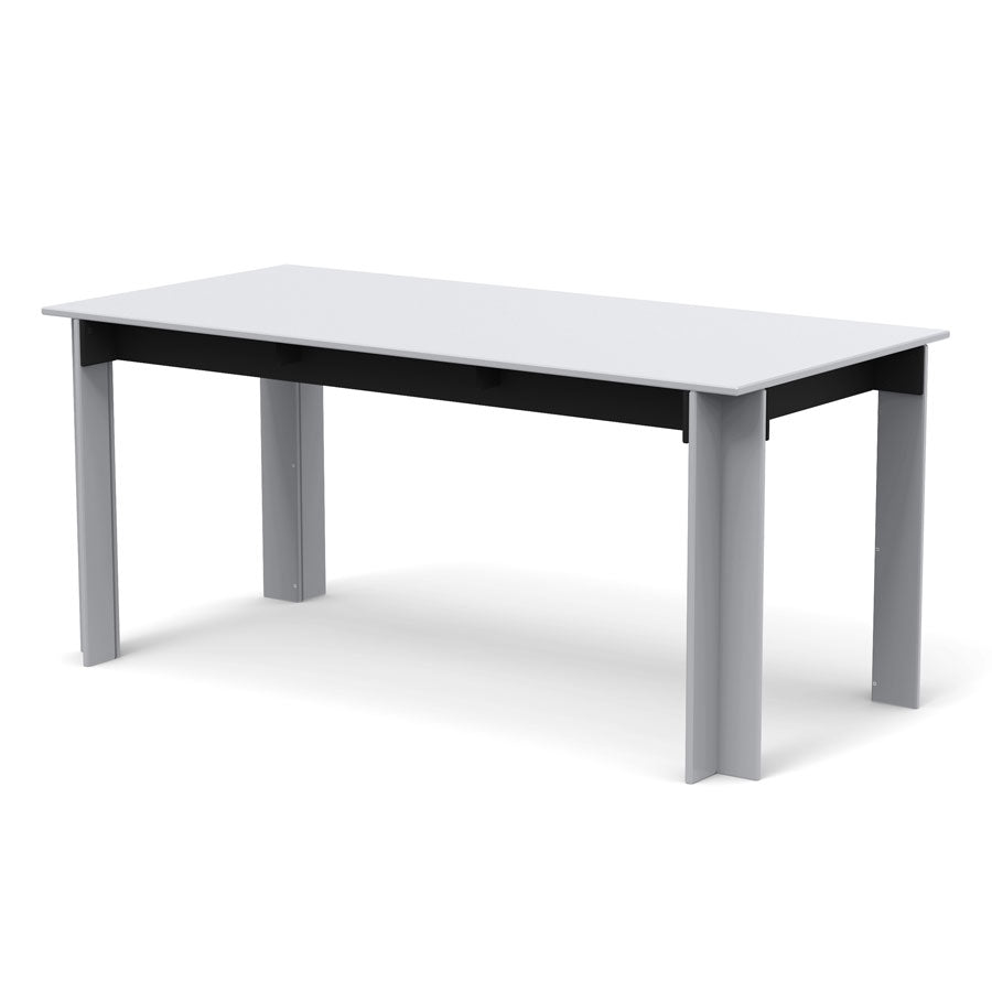 White desk with black support beam and two large leg supports, set with two chairs visible in background