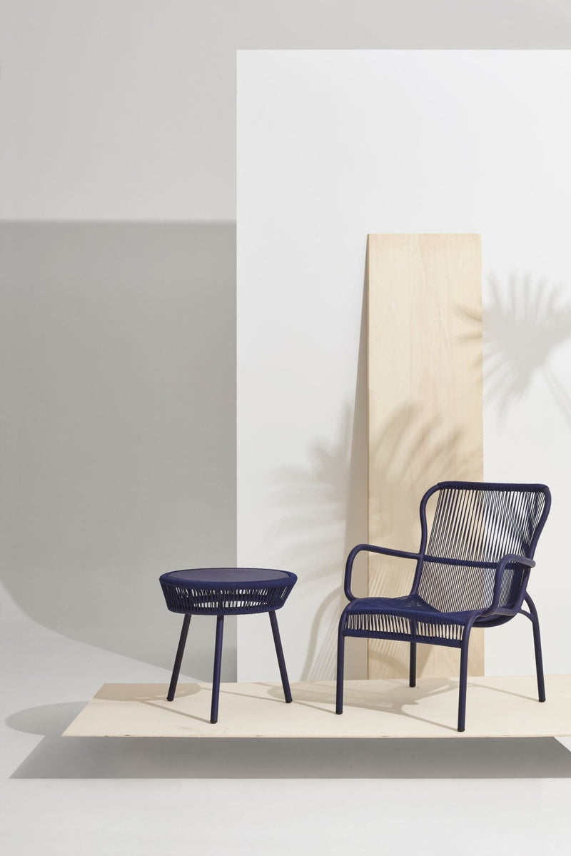 Close-up of black string chair with thin vertical cords and rounded arms.