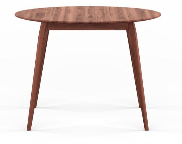 Round wooden table with light wood finish and slender legs in a minimal setting