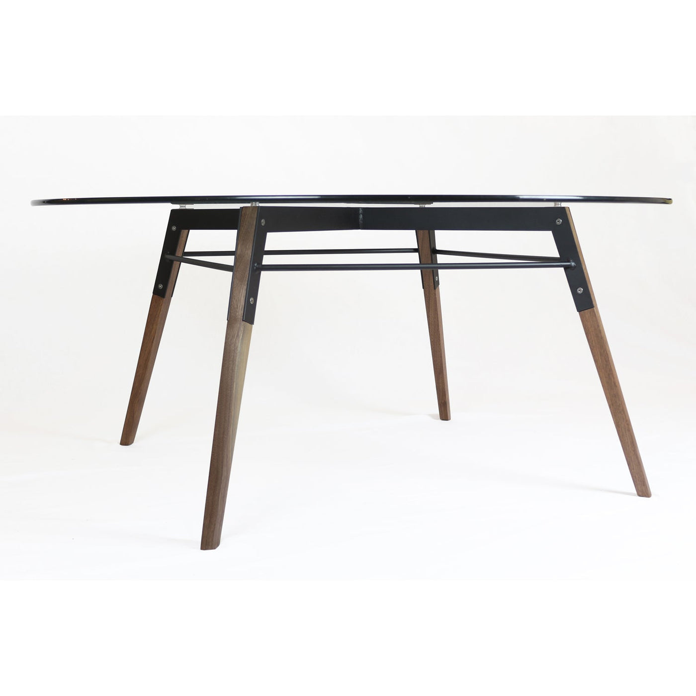 Round glass coffee table from a different angle, arched metal frame under the top, wooden legs with black metal brackets.