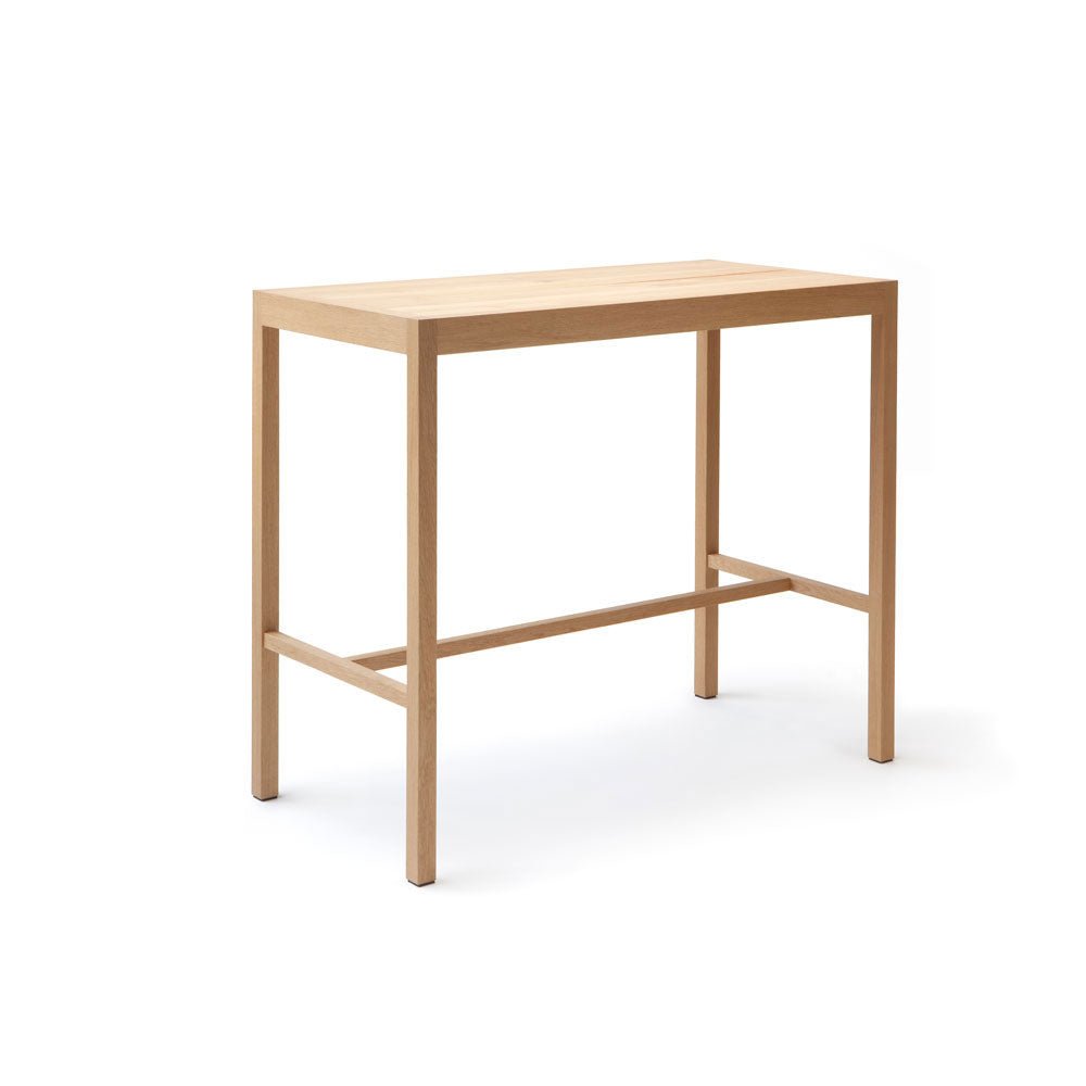 A light-colored wooden table with four legs and a simple frame, viewed from the front.