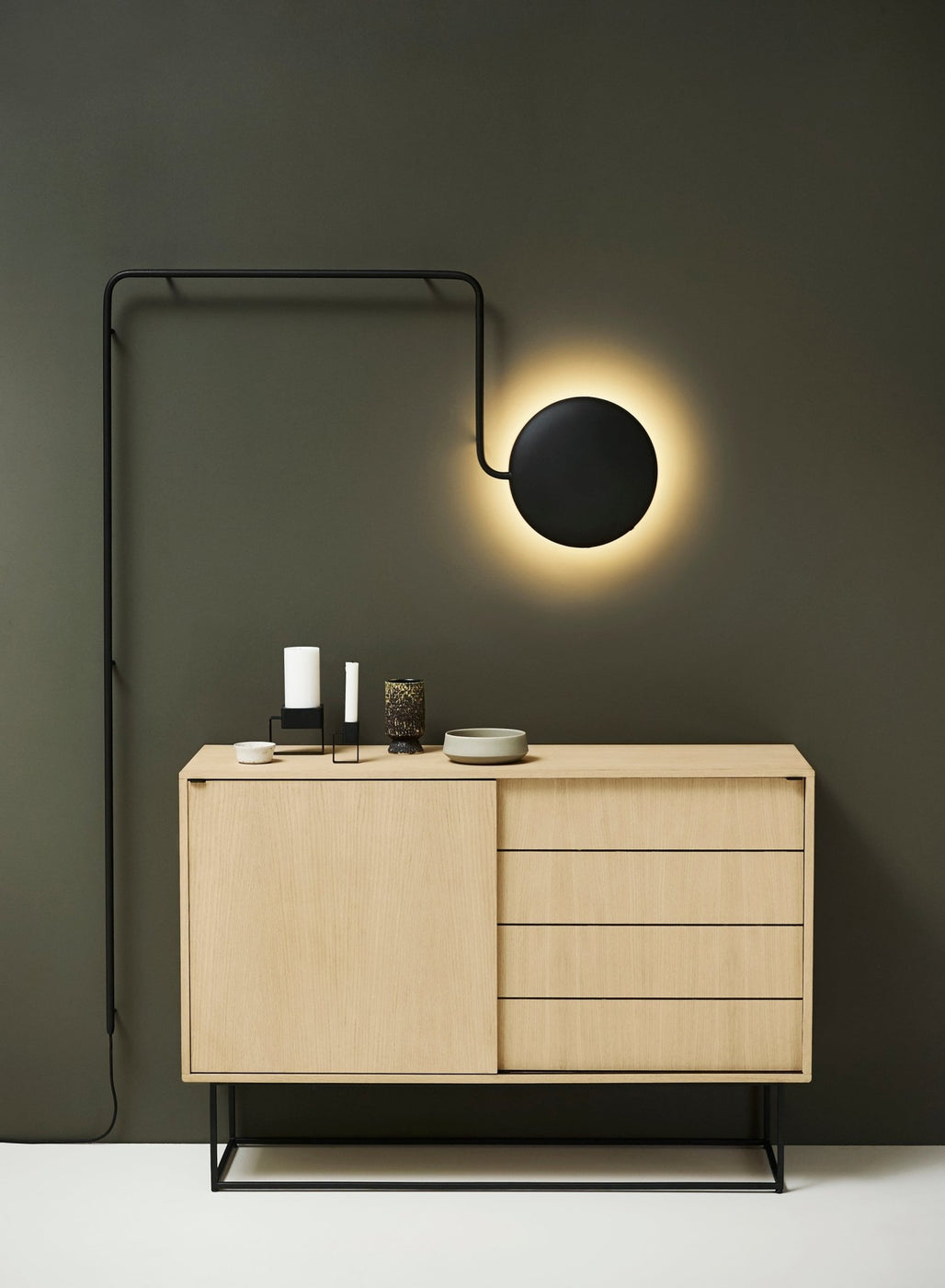 Close-up of wooden cabinet finish with natural wood grain and black metal frame base.